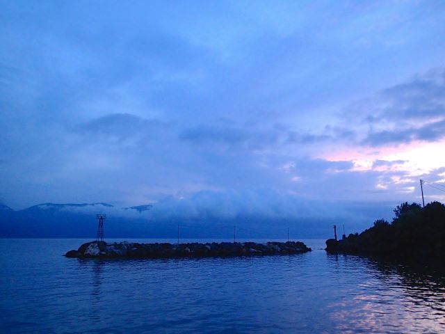 The wave breaker at Vathi may be junior-size but contributes to the coziness of the harbour--and to my peace of mind as storm clouds gather in the background.